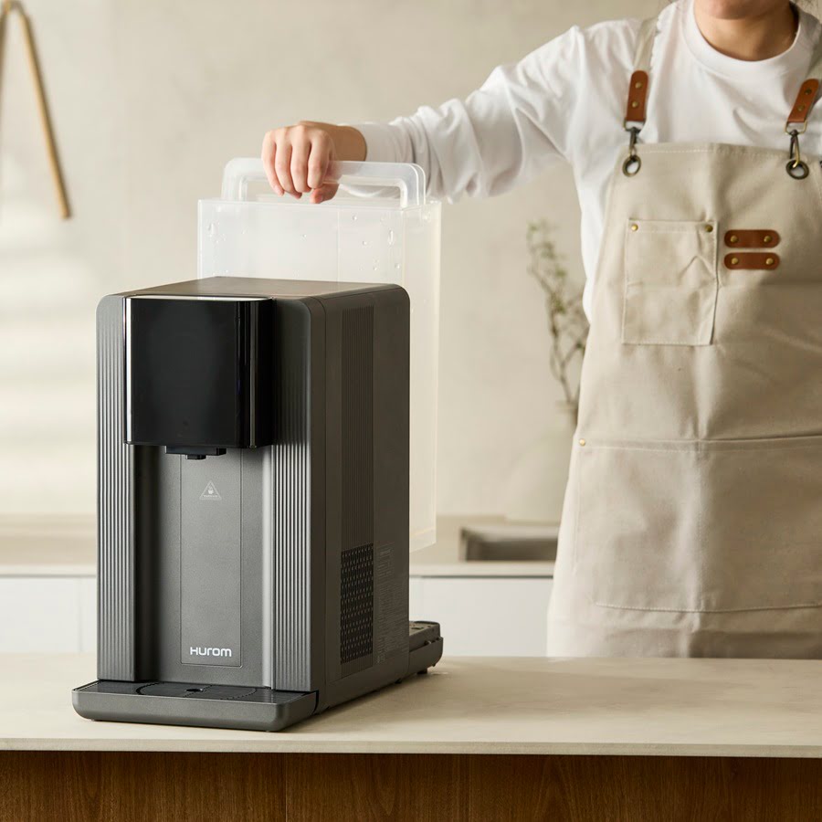 Hurom_Water_Purifier_WP-A01: Einsetzen des befüllten Wassertanks in das kompakte Tischgerät.