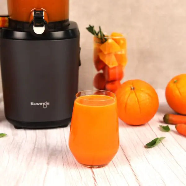 Kuvings AUTO8 Orangensaft mit Orangen rundum den Entsafter. 