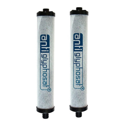 Zwei Ersatzfilter des PI Power Compact Antiglyphosat Filter Sets, liegend nebeneinander. Die Filter sind zylinderförmig, weiß mit der blauen Aufschrift „antiglyphosat®“ auf der Oberfläche und schwarzen Endkappen an beiden Seiten.
