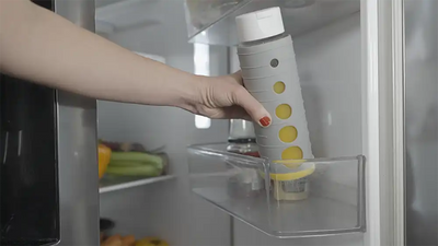 Person stellt Pika Vakuumflasche mit frisch gepresstem Orangensaft in den Kühlschrank.